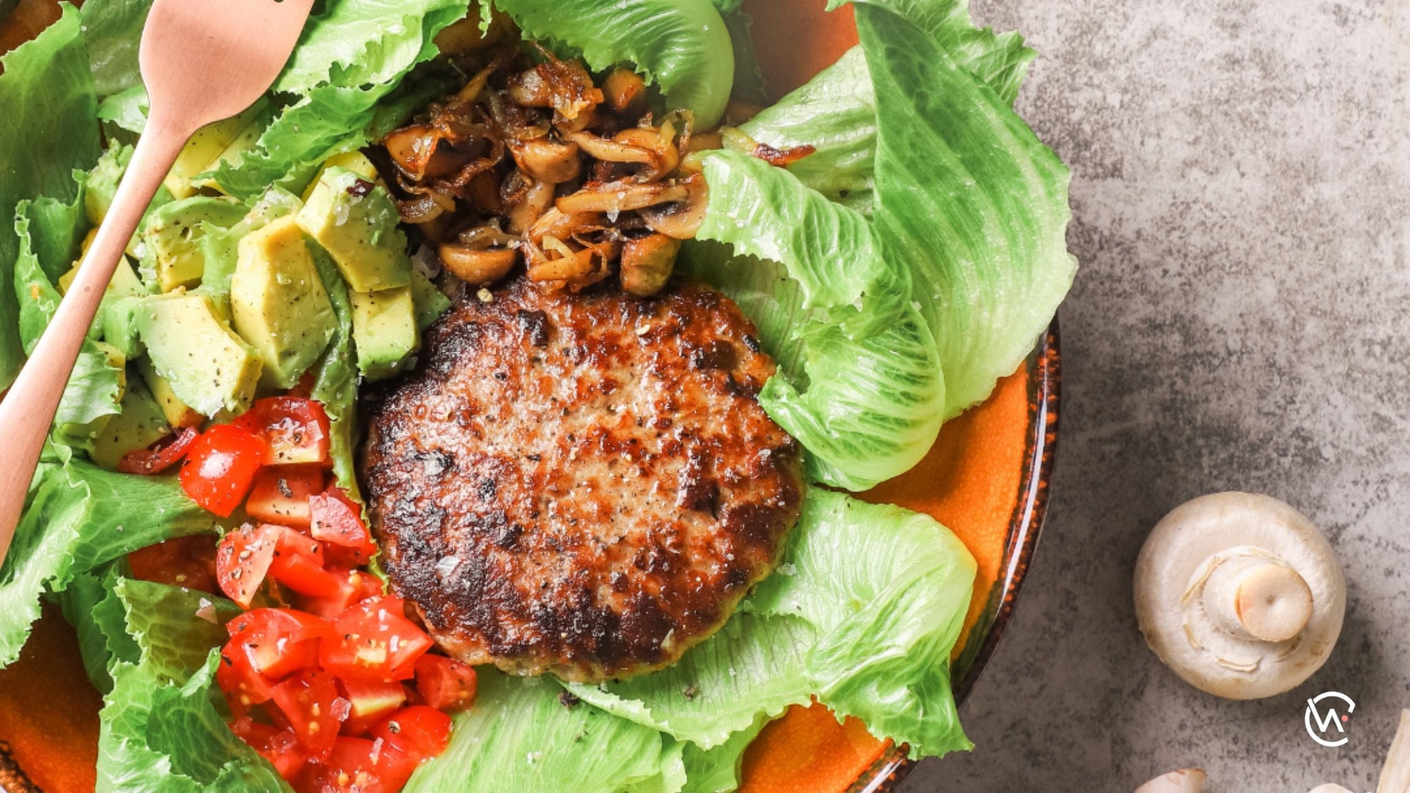 Burger patty with a Veggie Stack in a bowl of lettuce