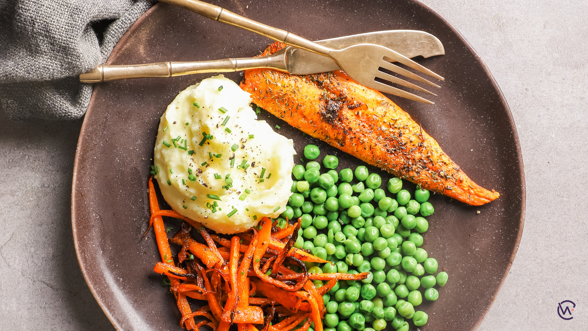 A plate of Chilli baked cod with garlic mashed potatoes, sautéed carrots & peas