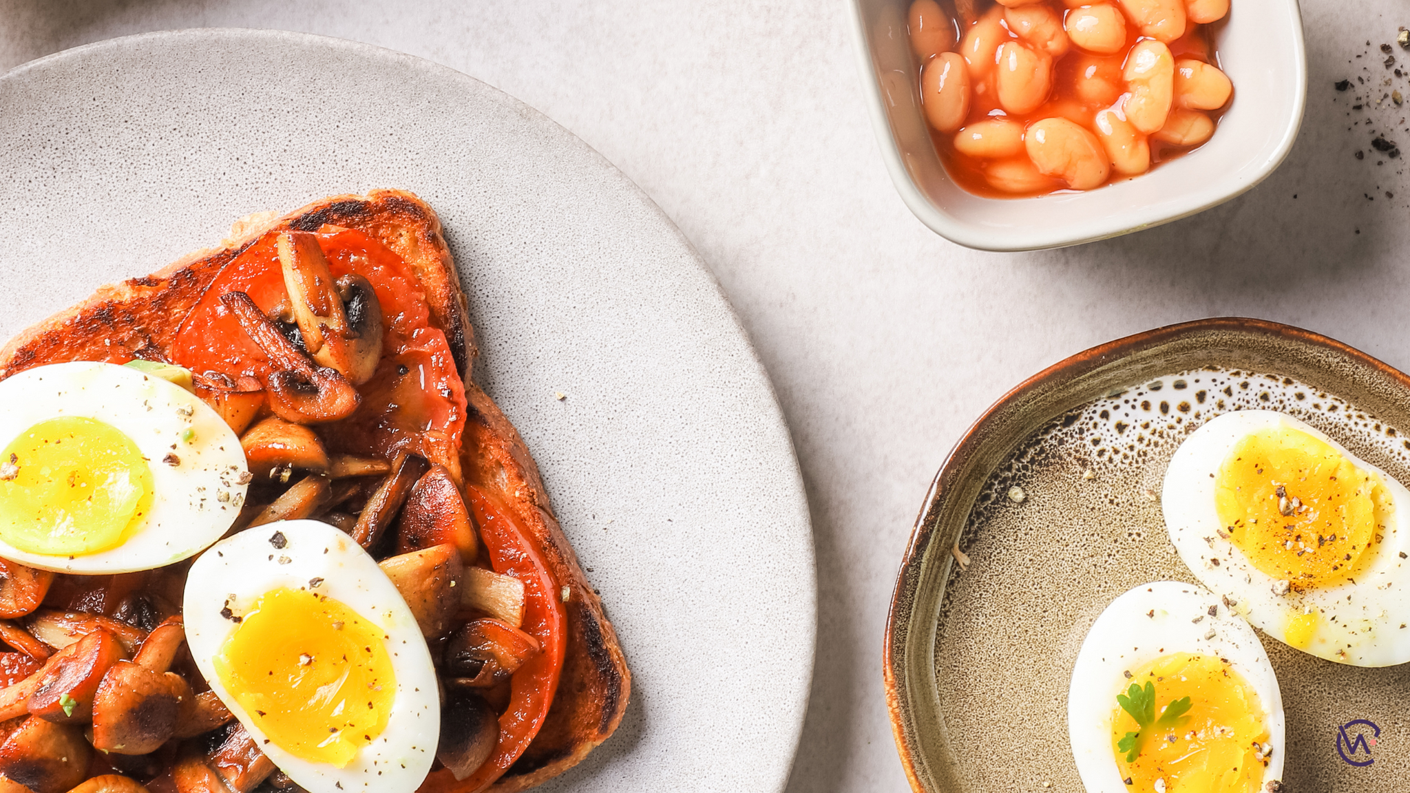 Boiled egg, mushrooms and tomato on toast with a side of baked beans and boiled egg
