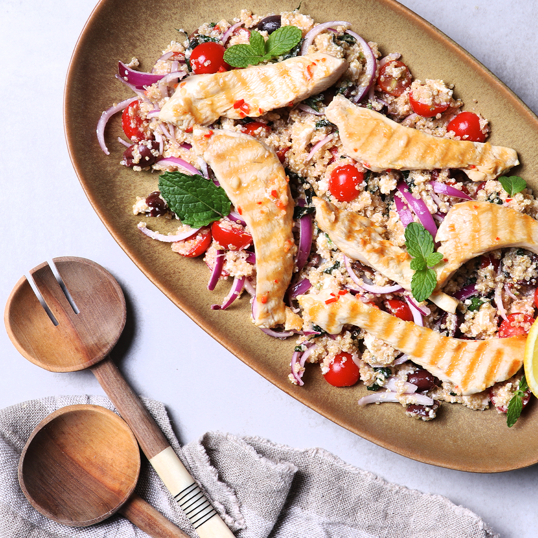 Grilled chicken in a quinoa salad on a plate