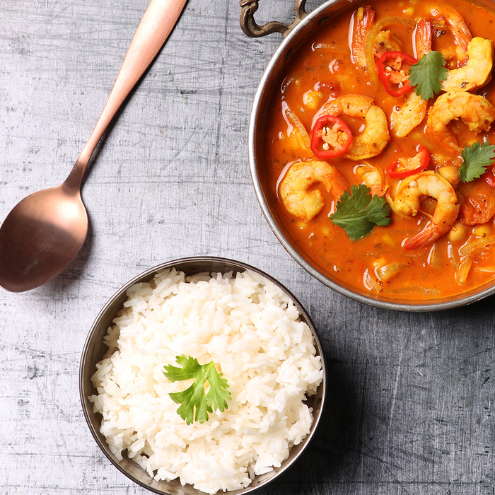 A bowl of Prawn and veg curry with rice on the side