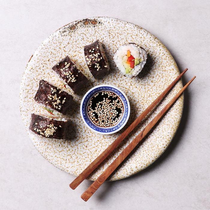 5 pieces of a sushi on a plate with chopsticks and soya sauce