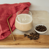 Prepare Cappuccino Shake in a glass with a straw, cloth and coffee beans next to it on a board
